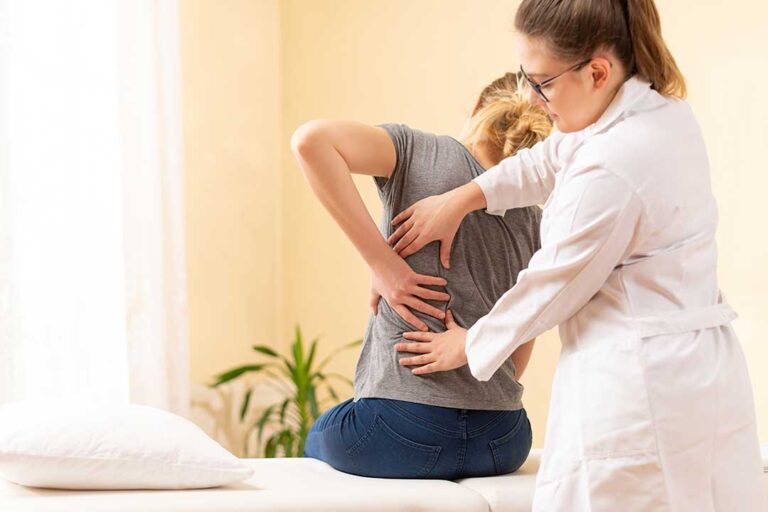 Person resting in a quiet room while a clinician gently assesses neck movement during a migraine discussion.