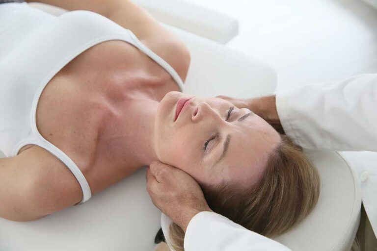 A chiropractor discussing a treatment plan with an adult patient in a comfortable clinic setting.